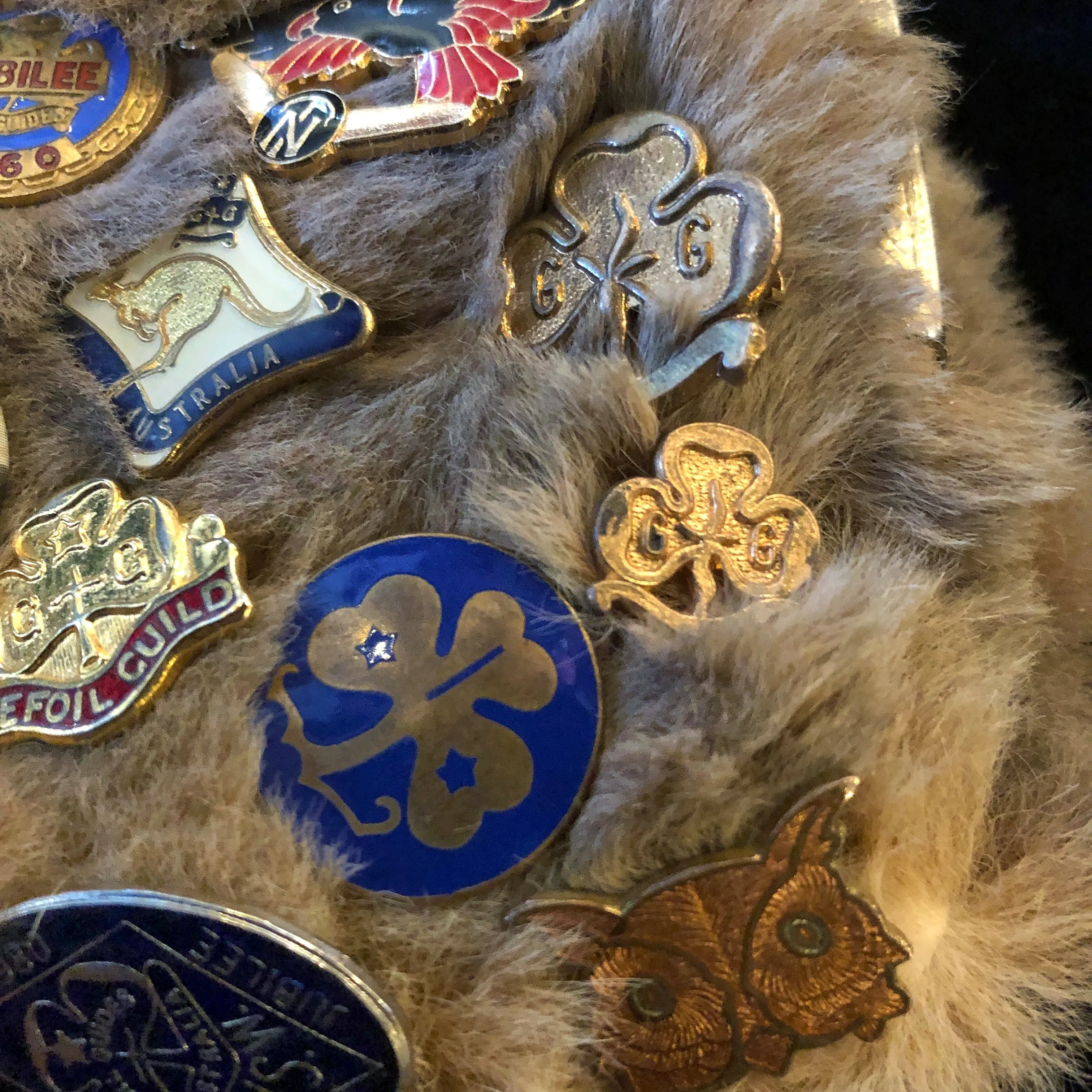A KANGAROO SKIN PURSE WITH 28 VINTAGE GIRL GUIDE PINS.