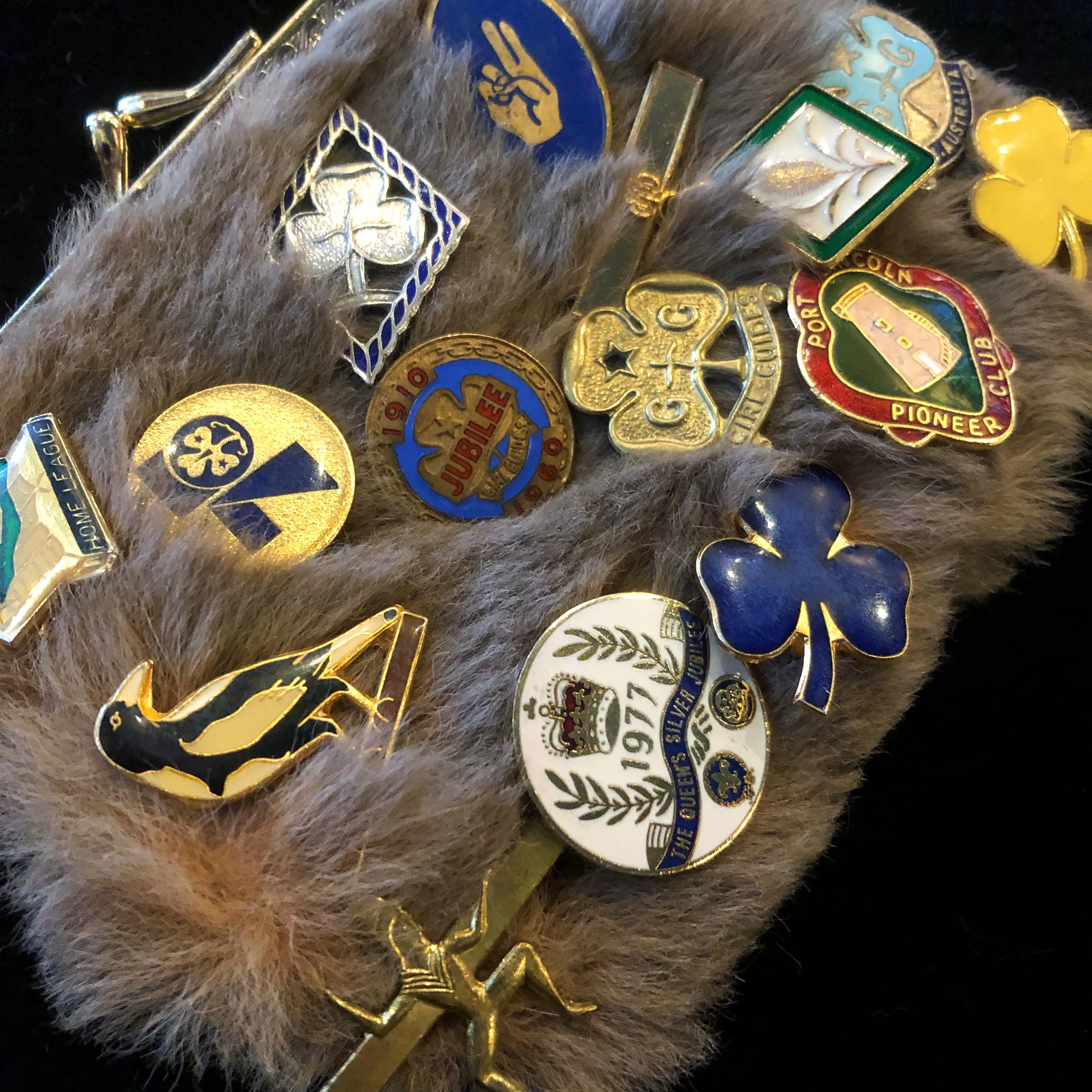 A KANGAROO SKIN PURSE WITH 28 VINTAGE GIRL GUIDE PINS.