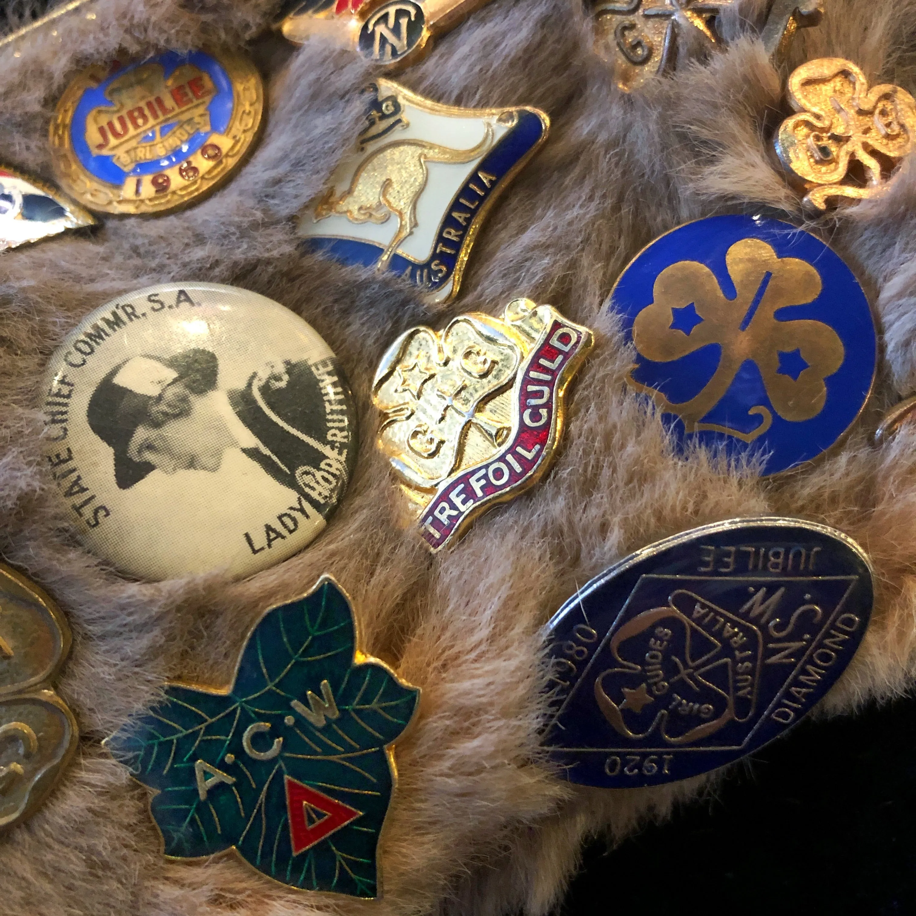 A KANGAROO SKIN PURSE WITH 28 VINTAGE GIRL GUIDE PINS.