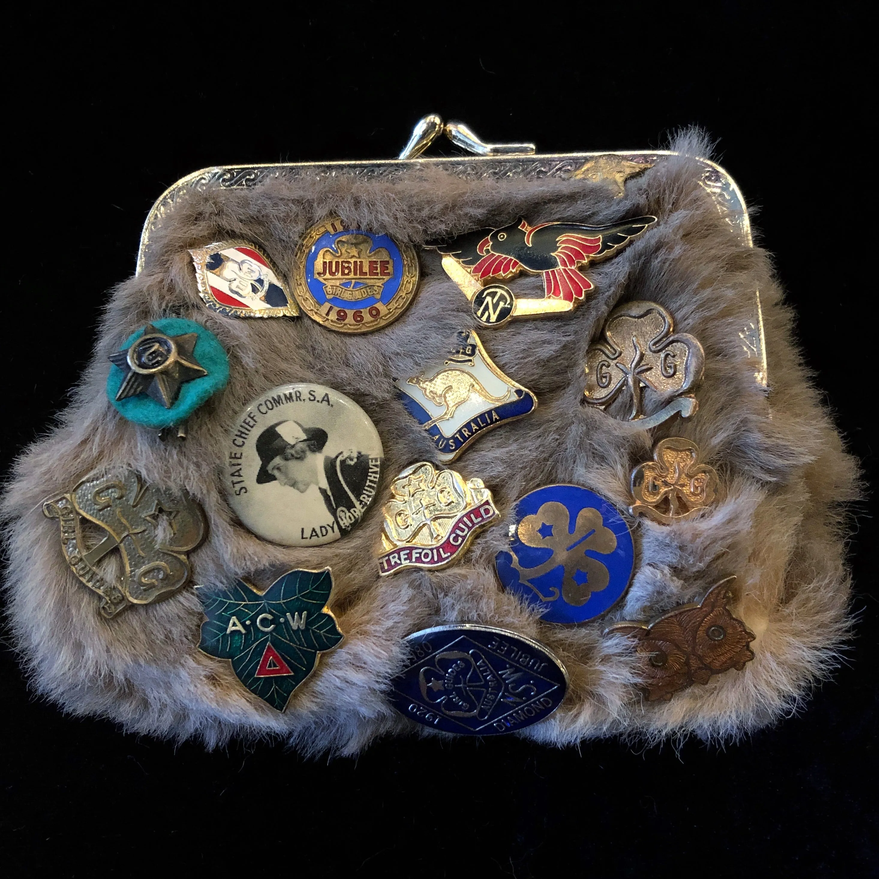 A KANGAROO SKIN PURSE WITH 28 VINTAGE GIRL GUIDE PINS.