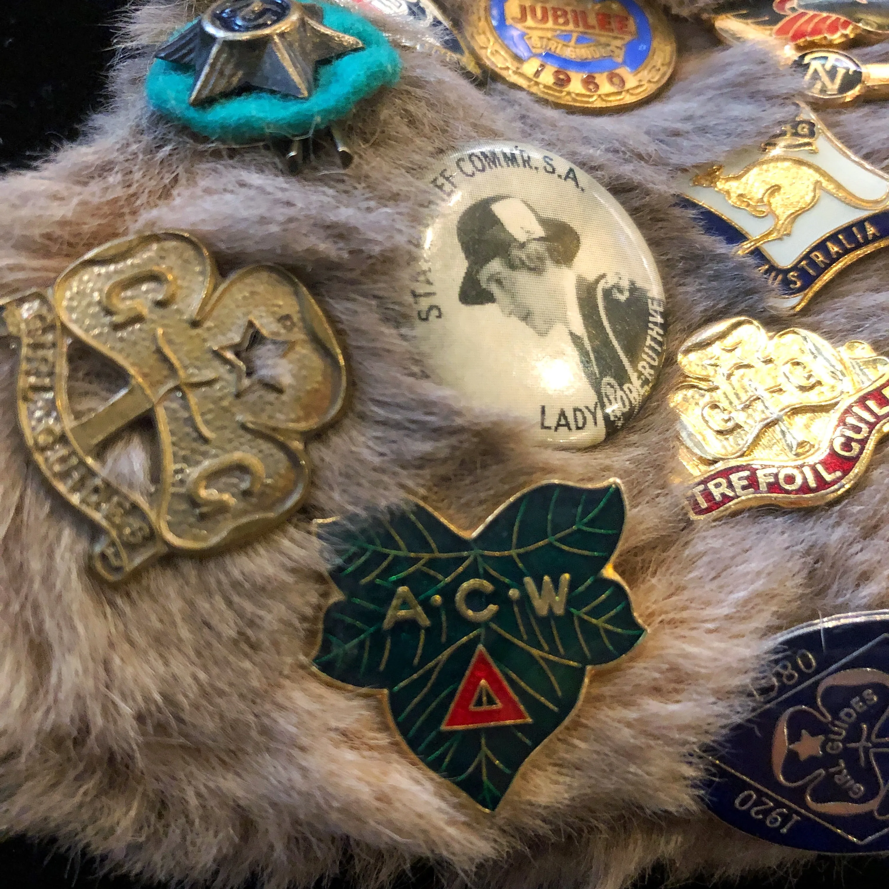 A KANGAROO SKIN PURSE WITH 28 VINTAGE GIRL GUIDE PINS.